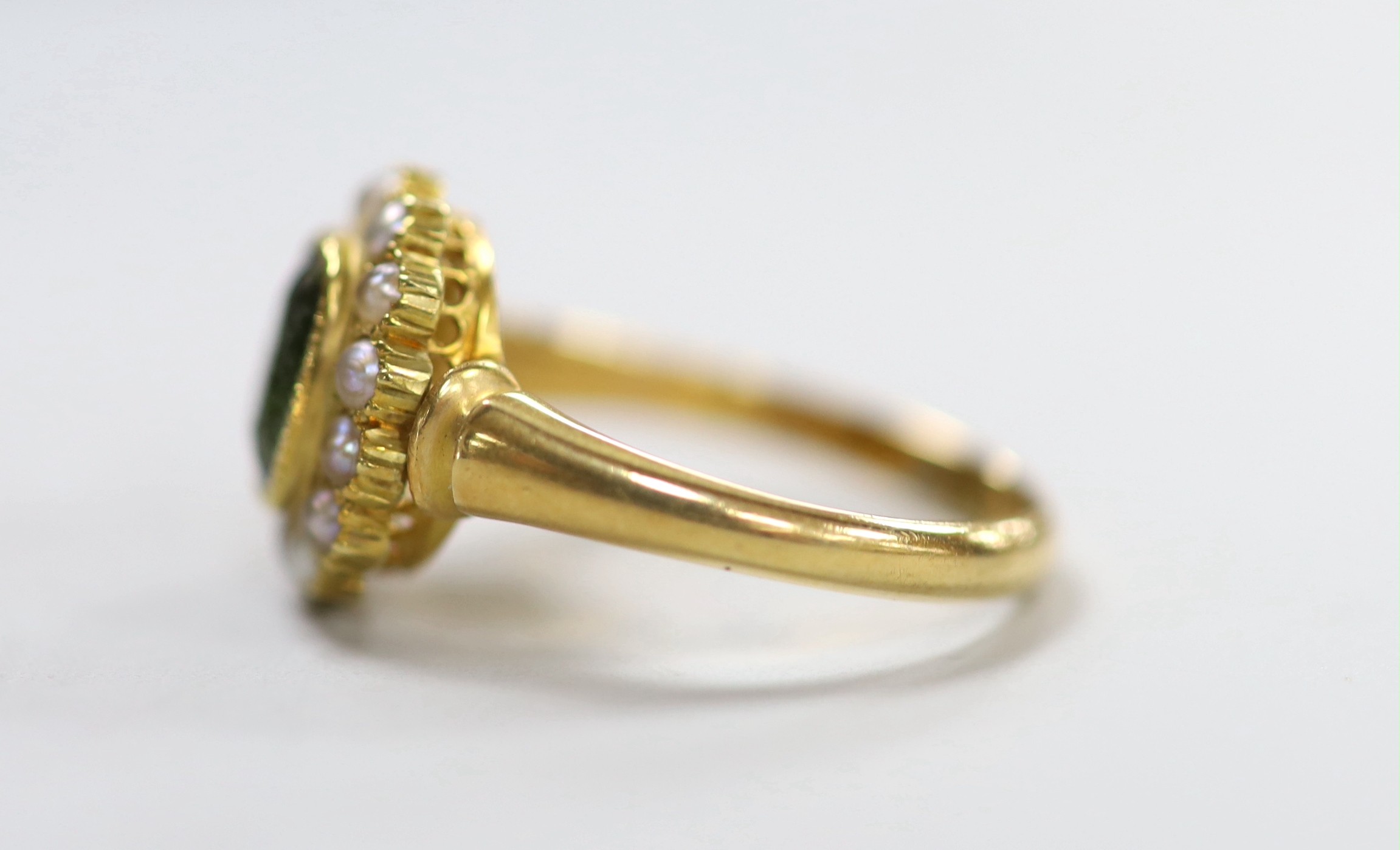 An Edwardian 18ct gold, green tourmaline and split pearl set oval cluster ring, size S, gross weight 6 grams.
